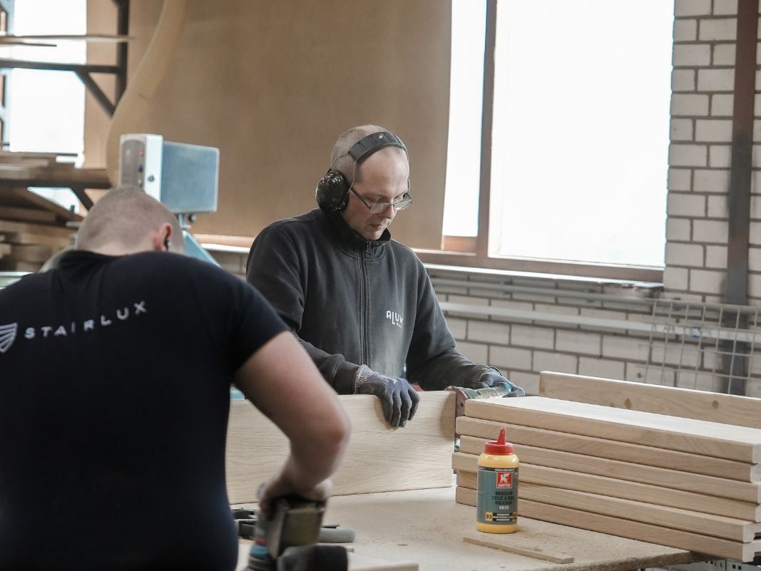 De timmerman die het hout aan het bewerken is.